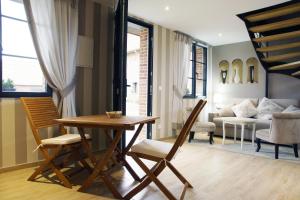 a living room with a table and chairs and a couch at La Cense - Ferme des Tilleuls in Houplines