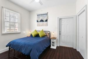 a bedroom with a bed with blue sheets and yellow pillows at Stylish Creole Cottage 1 BD Home Central Location in New Orleans