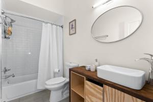 a bathroom with a sink and a toilet and a mirror at Stylish Creole Cottage 1 BD Home Central Location in New Orleans +8 photos