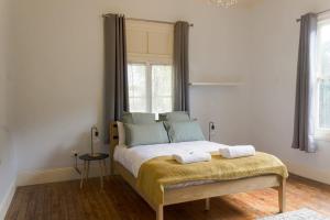 a bedroom with a large bed with two towels on it at Bultje Cottage - Walk to CBD, Pet Friendly in Dubbo