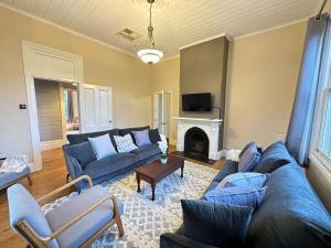 sala de estar con sofás azules y chimenea en Bultje Cottage - Walk to CBD, Pet Friendly en Dubbo