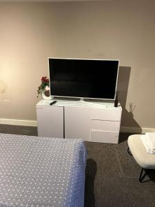 a flat screen tv on a white cabinet in a room at Clocktower Apartment in Kent