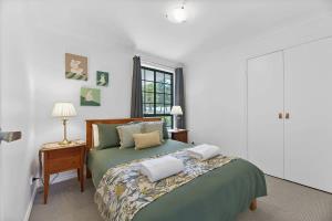 a bedroom with a green bed with two pillows on it at Anson Abode - CBD Home, Modern Sophistication in Orange