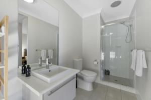a white bathroom with a sink and a shower at Serene Sullivan - Modern, Convenient, Pet Friendly in Orange +17 photos