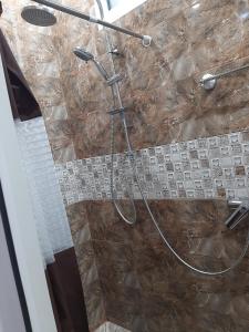 y baño con ducha y manguera. en Hotel Erebuni Plaza, en Ereván