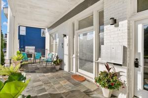 a porch with chairs and plants on a house at Modern pristine stunning 2BD Garden District Apt in New Orleans