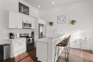 a kitchen with white cabinets and a counter top at Modern pristine stunning 2BD Garden District Apt in New Orleans