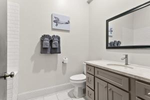 ein Badezimmer mit Waschbecken, Toilette und Spiegel in der Unterkunft Modern pristine stunning 2BD Garden District Apt in New Orleans + 12 Fotos