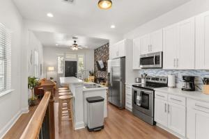 uma cozinha com armários brancos e electrodomésticos de aço inoxidável em Fabulous Classy and Comfy 3BD 2BA Home and Parking em Nova Orleans
