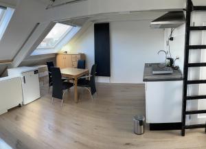 a kitchen and dining room with a table and chairs at Zolderstudio dichtbij Goffert met eigen badkamer en WC, eigen keuken, eigen ingang in Nijmegen