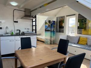 een keuken en eetkamer met een tafel en een bank bij Studio met eigen badkamer en eigen keuken in Nijmegen