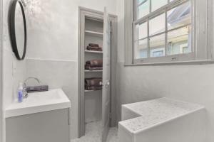 a white bathroom with a sink and a mirror at Spacious Mid City 1BD On The Canal Streetcar Line in New Orleans