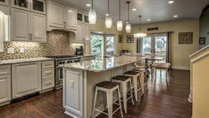 a kitchen with white cabinets and a large island with bar stools at Jump Right In in Blue Ridge