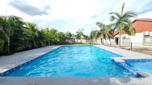 a swimming pool with blue water and palm trees at Artem Apartments - Apartment 3 in Kitwe