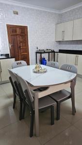 a white table and chairs in a kitchen at Artem Apartments - Apartment 3 in Kitwe