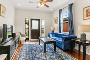 a living room with a blue couch and a tv at Pristine and comfy Mid-City 2BD 1BA in New Orleans