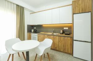 a kitchen with a white table and two white chairs at the 203 in Giannitsa