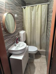 a bathroom with a toilet and a sink and a mirror at Apartments Ohrid Lake in Ohrid