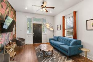 uma sala de estar com um sofá azul e uma ventoinha de tecto em Garden District 3BD 2BA Parking Stylish & Unique em Nova Orleans