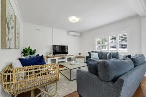 a living room with two blue couches and a tv at Hope St Cottage - Elegant & Cosy, Sleeps 6 in Bathurst