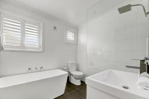 a white bathroom with a tub and a toilet at Hope St Cottage - Elegant & Cosy, Sleeps 6 in Bathurst +16 photos