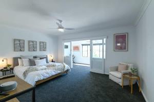 a bedroom with a bed and a table and a couch at Tamworth Retreat - Sleek & Stylish, Sleeps 5 in Dubbo