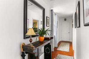 a hallway with a mirror and a table with a lamp at Lil Red Door Perfect 1BD in Bywater with Courtyard in New Orleans