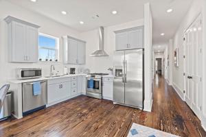 ニューオーリンズにあるLuxury 4BD with Pool and off street parkingの白いキャビネットとステンレス製の冷蔵庫を備えたキッチン