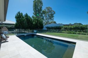 a swimming pool in the backyard of a house at Regand Retreat - Luxurious Family Home, Pool in Dubbo