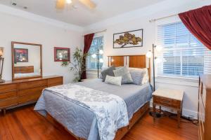 a bedroom with a bed and a dresser and a window at The Nelson House Unbeatable Location in New Orleans