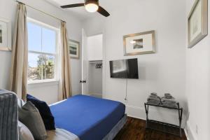 a bedroom with a blue bed and a tv at Elegant 4bd with Pool and Off Street Parking in New Orleans