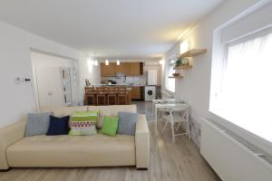 a living room with a couch and a kitchen at Stardust apartman in Pécs