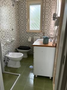 a bathroom with a toilet and a sink at Villa Paola by the sea in Cozze +32 photos