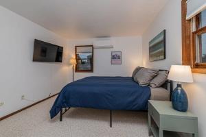 1 dormitorio con 1 cama azul y TV en Fall Getaway in Cozy 2BR near Old Town Lafayette, en Lafayette