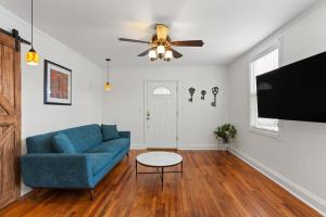 a living room with a blue couch and a ceiling fan at 4BD Metairie retreat with driveway and yard in Metairie