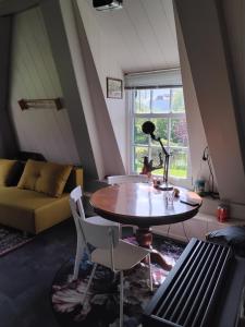 a living room with a table and chairs and a couch at Slapen bij de molenaar in Leerdam