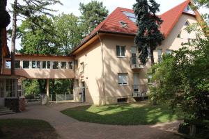 un edificio con techo rojo y patio en Wellness Hotel Szindbád, en Balatonszemes