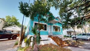 a blue house with stairs in a street at Sunny 5Bed w Parking and direct Streetcar access in New Orleans