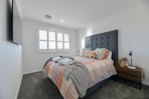 ein Schlafzimmer mit einem großen Bett und einem Fenster in der Unterkunft Hideaway on Curran - CBD Escape, EV Plug, Firepit in Orange