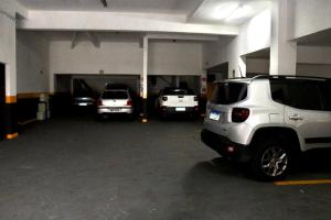 a garage with three cars parked in it at GM Hotel SP in Utinga