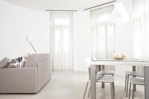 a white living room with a table and a couch at Palazzo Talenti 1907 in Trieste
