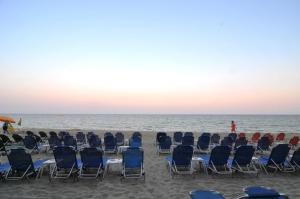 un grupo de sillas sentadas en la playa en Panorama Hotel en Paralia Katerinis