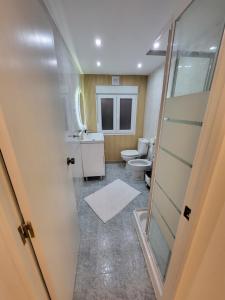 a bathroom with a toilet and a sink at CASA MADRID 2 minutos a la playa in Cullera +27 photos