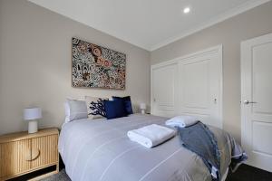 a bedroom with a bed with two towels on it at Paradise on Prince - Sleek & Stylish, Dog Friendly in Orange