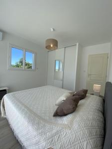 um quarto branco com uma cama grande e 2 almofadas em Villa Piazzola em Petreto-Bicchisano