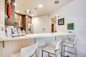 uma cozinha com cadeiras brancas e uma bancada em Modern Sedona Guesthouse with Patio, Walk to Trails! em Sedona