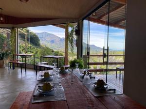 a dining room with a table with a view of the mountains at Chalés Família Onofre in Divisa