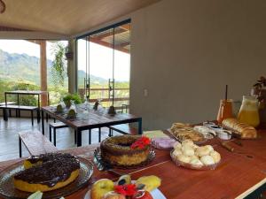 a table with many different types of food on it at Chalés Família Onofre in Divisa