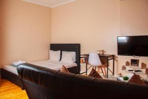 a living room with a couch and a flat screen tv at Studio 110 in Luanda