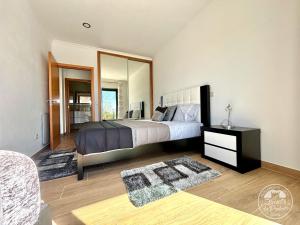 a bedroom with a large bed and a mirror at Pavilhão 1 - Quinta da Prelada Simão in Celorico de Basto